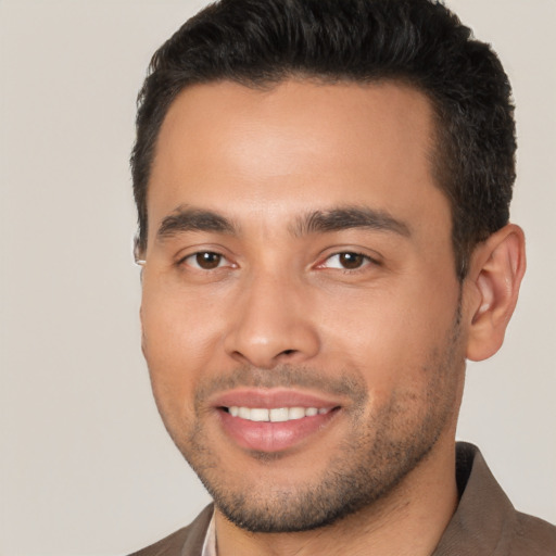 Joyful latino young-adult male with short  black hair and brown eyes