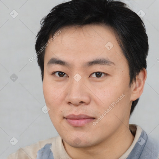 Joyful asian young-adult male with short  brown hair and brown eyes