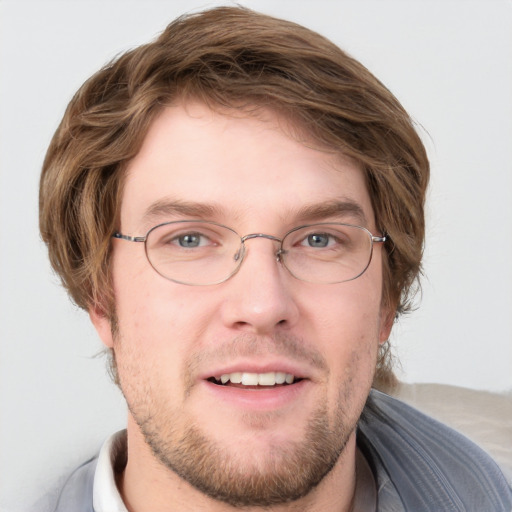 Joyful white young-adult male with short  brown hair and blue eyes