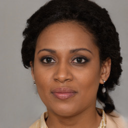 Joyful black young-adult female with long  brown hair and brown eyes