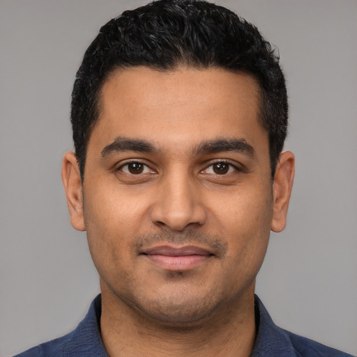 Joyful latino young-adult male with short  black hair and brown eyes