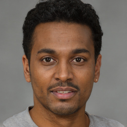 Joyful latino young-adult male with short  brown hair and brown eyes