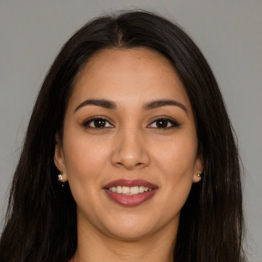 Joyful latino young-adult female with long  brown hair and brown eyes