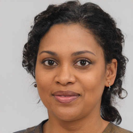 Joyful black young-adult female with medium  brown hair and brown eyes
