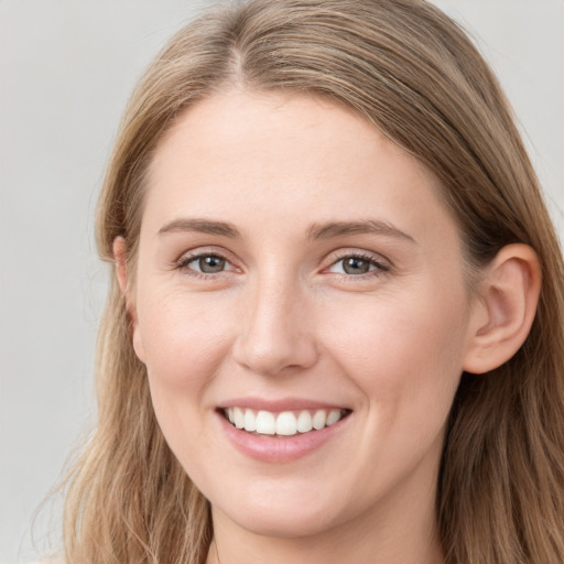 Joyful white young-adult female with long  brown hair and blue eyes