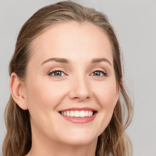 Joyful white young-adult female with long  brown hair and blue eyes