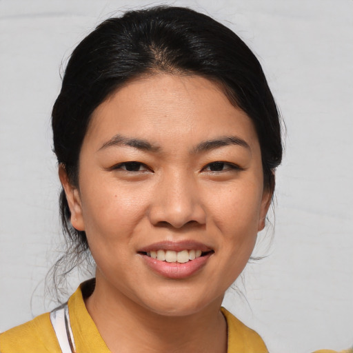 Joyful asian young-adult female with medium  brown hair and brown eyes