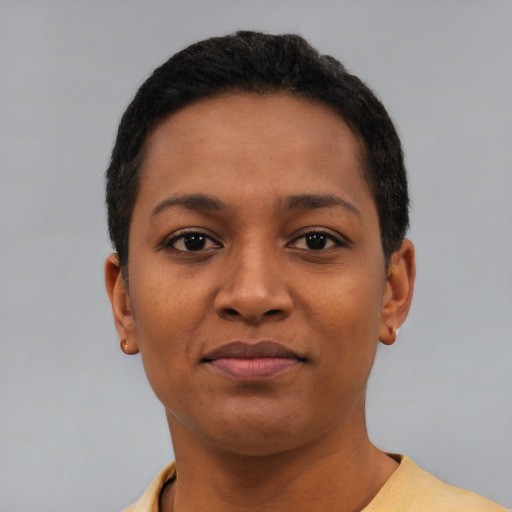 Joyful black young-adult female with short  black hair and brown eyes