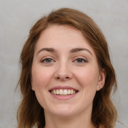 Joyful white young-adult female with medium  brown hair and green eyes