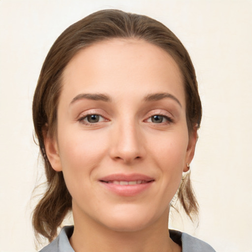 Joyful white young-adult female with medium  brown hair and grey eyes