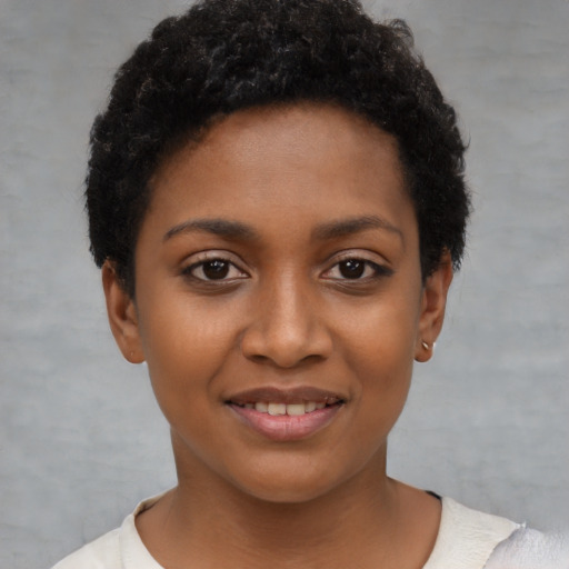 Joyful black young-adult female with short  black hair and brown eyes
