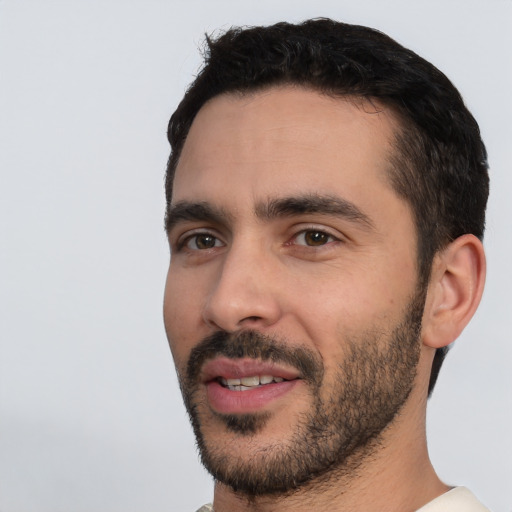 Joyful white young-adult male with short  black hair and brown eyes