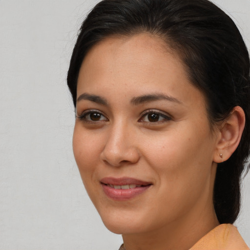 Joyful latino young-adult female with long  brown hair and brown eyes