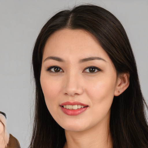 Joyful asian young-adult female with long  brown hair and brown eyes