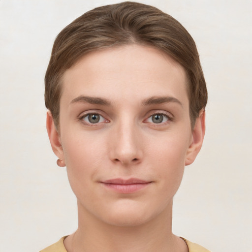 Joyful white young-adult female with short  brown hair and grey eyes