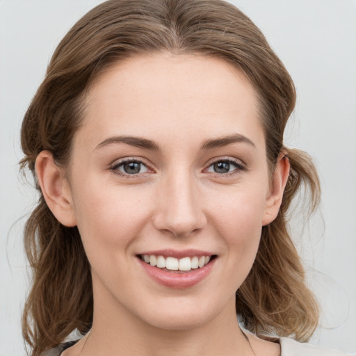 Joyful white young-adult female with medium  brown hair and grey eyes