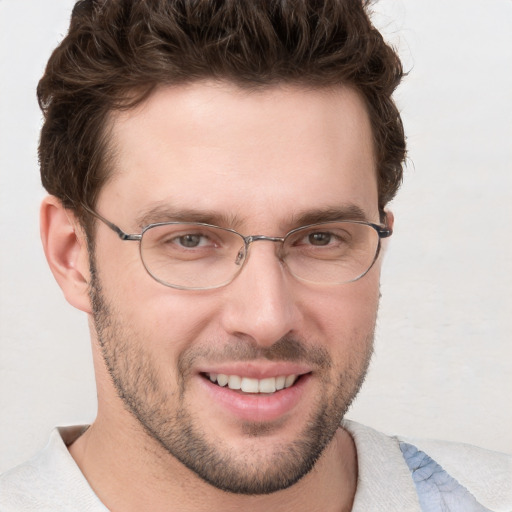 Joyful white young-adult male with short  brown hair and blue eyes