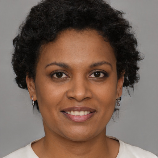 Joyful black young-adult female with short  brown hair and brown eyes