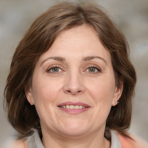 Joyful white adult female with medium  brown hair and grey eyes