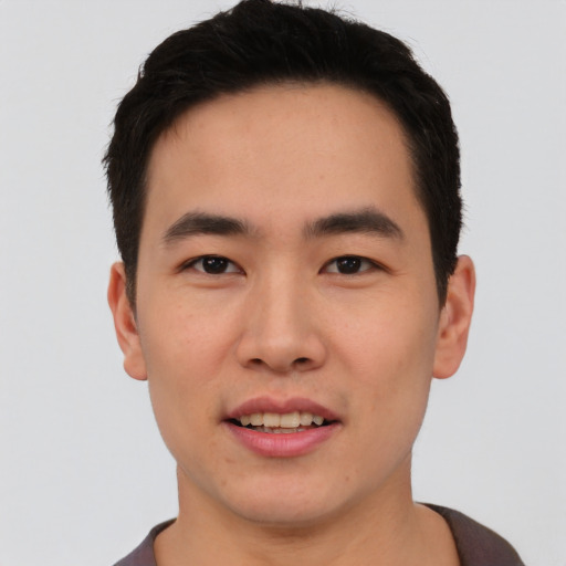 Joyful asian young-adult male with short  black hair and brown eyes