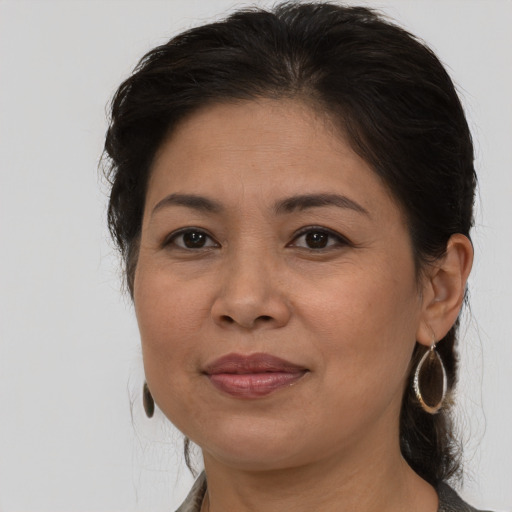Joyful latino adult female with medium  brown hair and brown eyes