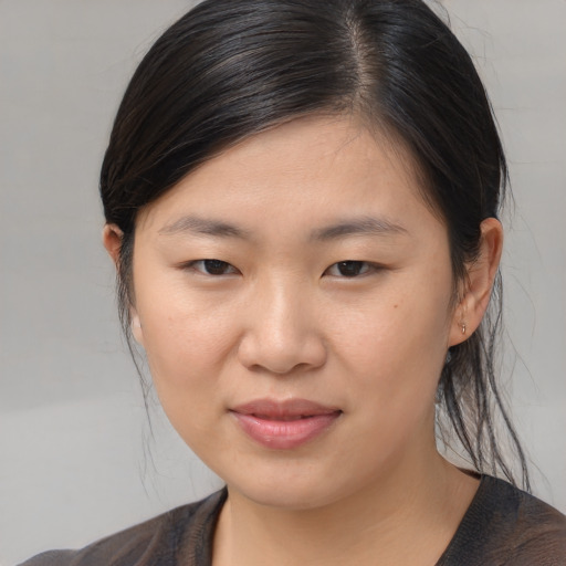 Joyful asian young-adult female with medium  brown hair and brown eyes