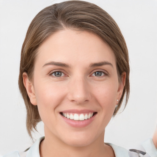 Joyful white young-adult female with medium  brown hair and grey eyes