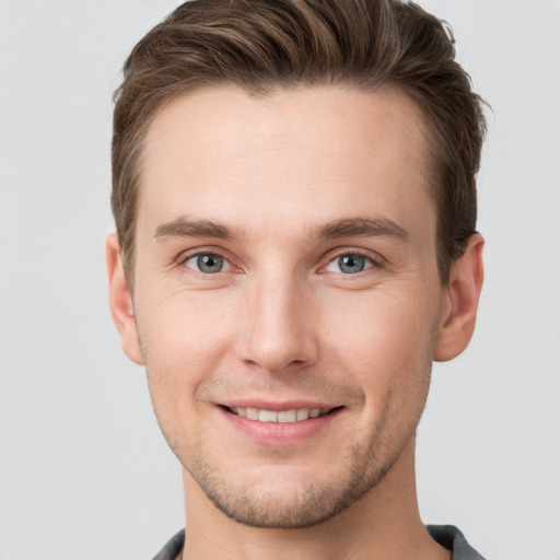 Joyful white young-adult male with short  brown hair and grey eyes