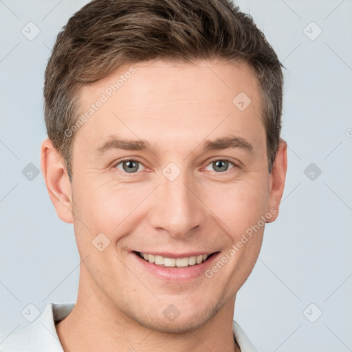 Joyful white young-adult male with short  brown hair and grey eyes