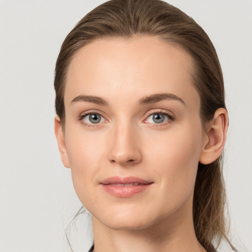 Joyful white young-adult female with long  brown hair and grey eyes