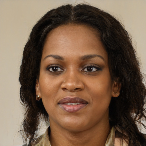 Joyful black adult female with long  brown hair and brown eyes