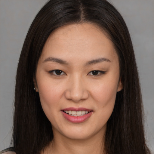Joyful asian young-adult female with long  brown hair and brown eyes