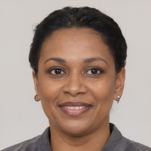 Joyful black adult female with short  black hair and brown eyes