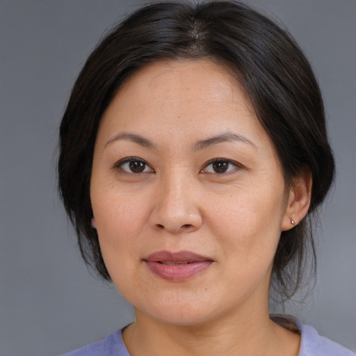 Joyful asian adult female with medium  brown hair and brown eyes