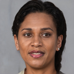 Joyful latino adult female with medium  brown hair and brown eyes