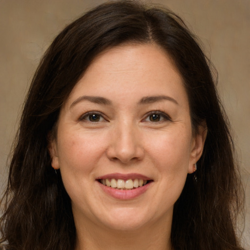 Joyful white adult female with long  brown hair and brown eyes