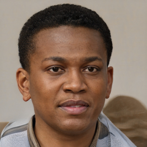 Joyful black young-adult male with short  brown hair and brown eyes