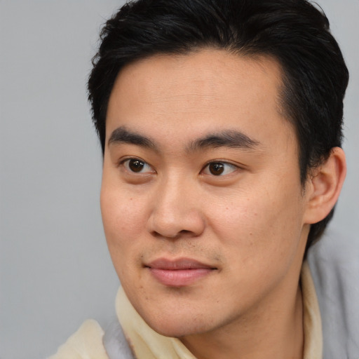 Joyful asian young-adult male with short  brown hair and brown eyes
