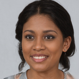 Joyful black young-adult female with medium  brown hair and brown eyes