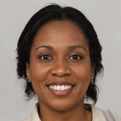Joyful black adult female with medium  brown hair and brown eyes