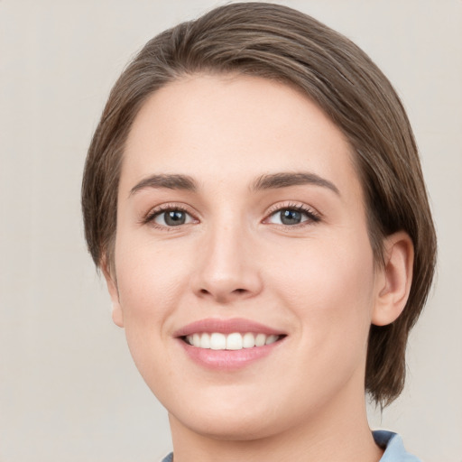 Joyful white young-adult female with medium  brown hair and green eyes