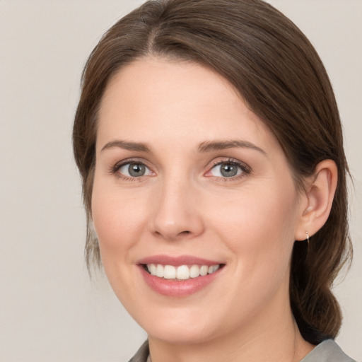 Joyful white young-adult female with medium  brown hair and grey eyes