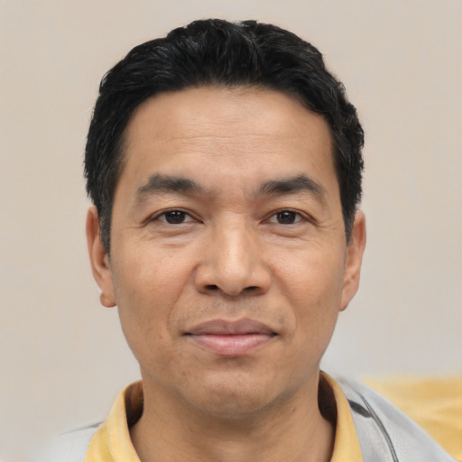 Joyful asian adult male with short  black hair and brown eyes