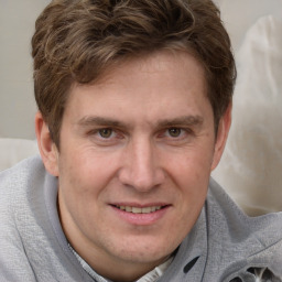 Joyful white adult male with short  brown hair and brown eyes