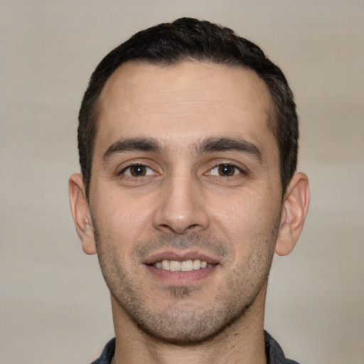 Joyful white young-adult male with short  black hair and brown eyes