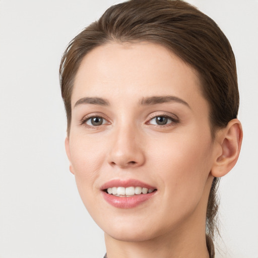 Joyful white young-adult female with long  brown hair and grey eyes