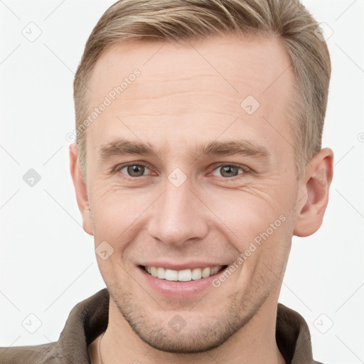 Joyful white young-adult male with short  brown hair and grey eyes