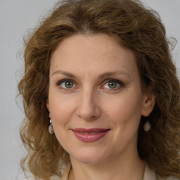 Joyful white young-adult female with medium  brown hair and green eyes