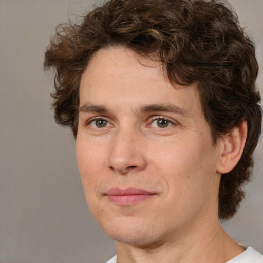 Joyful white adult male with medium  brown hair and brown eyes