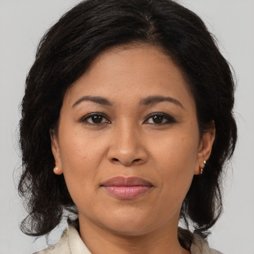 Joyful latino adult female with medium  brown hair and brown eyes